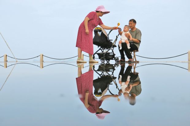 An elderly couple tease their grandson in Yantai, Shandong Province of China to illustrate Ten years to prepare for demographic cliff edge, China warned