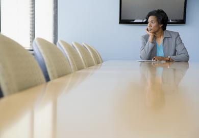 Woman sitting alone at boardroom table